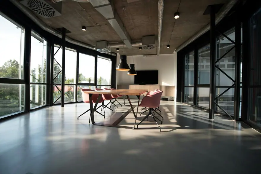 Open office with a long meeting table and glass walls